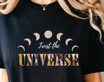 May include: Black t-shirt with a floral design and the text "Trust the Universe" with a crescent moon graphic.