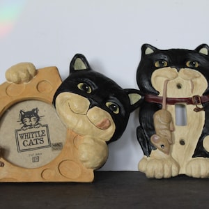 May include: Whittle Cats themed decorative items. Includes a cheese-shaped picture frame with a cat graphic and a mouse, and a black and white cat light switch cover holding a mouse. Hand painted.