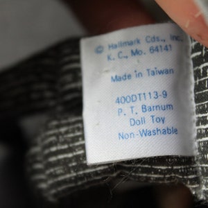 May include: White tag with blue text that reads "Hallmark Cds., Inc. K. C., Mo. 64141 Made in Taiwan 400DT113-9 P. T. Barnum Doll Toy Non-Washable"
