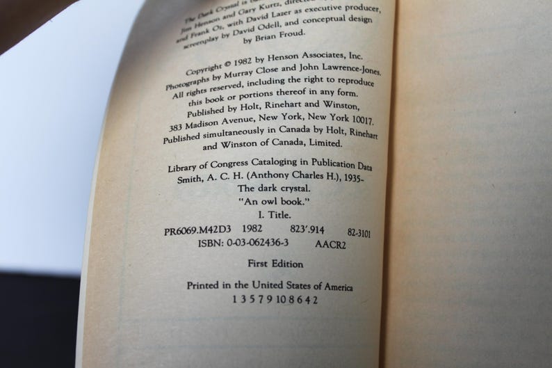 May include: A page from a book titled "The Dark Crystal" with text including copyright information, publisher details, and Library of Congress data. The text is in black font on a cream-colored paper. The book is a first edition.