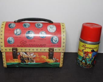 Boîte à lunch et thermos vintage Aladdin Buccaneer en métal. Excellent état, quelques petits défauts. Cadeau idéal pour un collectionneur. Coffre au trésor de pirate.
