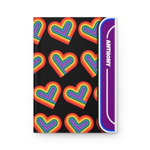May include: A black notebook with a rainbow heart pattern and a purple spine with the name "ANTHONY" printed on it.
