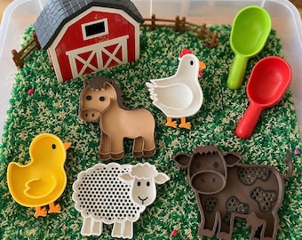 Può includere: Un set per vaschetta sensoriale con una stalla in plastica rossa e bianca, un cavallo marrone, una gallina bianca, un'anatra gialla, una pecora bianca e una mucca marrone. Il set include un paletta verde, una rossa e una staccionata marrone.