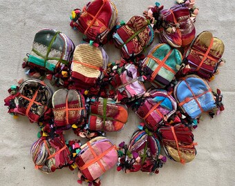 May include: A collection of colorful fabric pouches with intricate patterns and designs. The pouches are made of various fabrics, including silk, cotton, and velvet. They are perfect for storing small items, such as jewelry, coins, or keys.