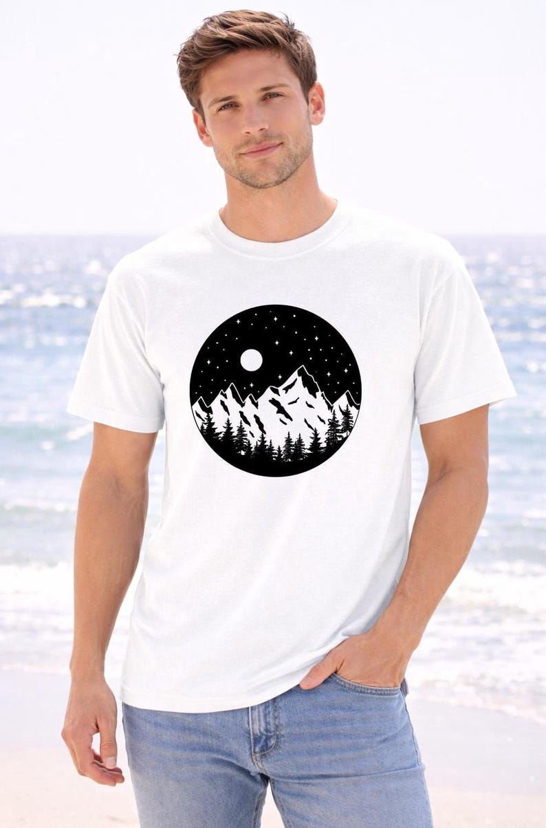 A man wearing a white t-shirt with a black and white graphic of mountains and a night sky.