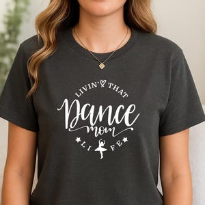 A woman wearing a black t-shirt with white text and a graphic design.
