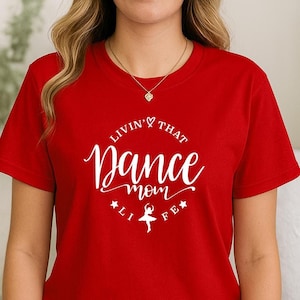 A woman wearing a red t-shirt with white text and a graphic design.