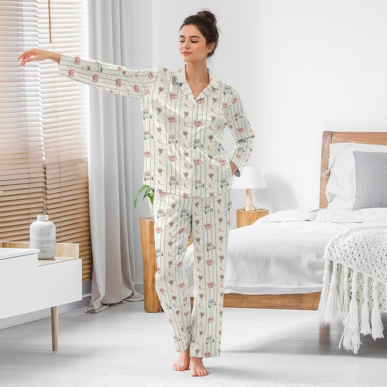 K&ouml;nnte beinhalten: Cremefarbenes Pyjama-Set mit einem Hemd zum Kn&ouml;pfen und passender Hose. Das Set hat ein sich wiederholendes Muster aus kleinen, skurrilen Illustrationen in Rosa, Grau und Braun mit vertikalen Streifen. Der Pyjama hat einen klassischen Kragen und eine lockere Passform.