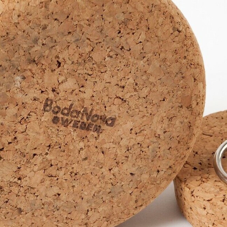 Puede incluir: Primer plano de la parte inferior de un tap&oacute;n de botella de corcho con el texto "Bodanova Sweden" impreso en el corcho.