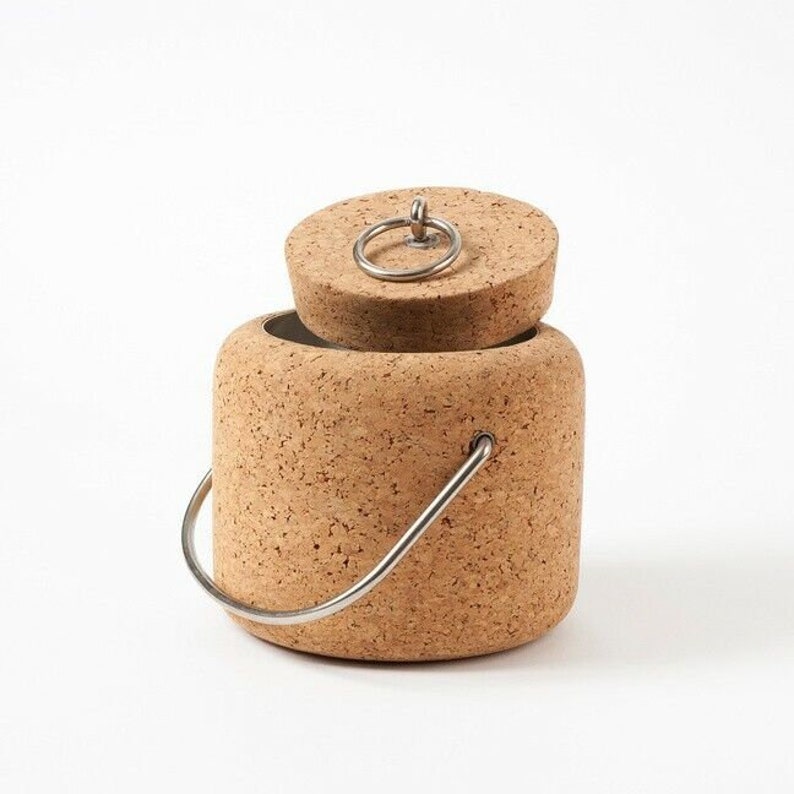 Puede incluir: Un cubo de hielo de corcho con un asa y una tapa de metal. La tapa tiene un anillo de metal para una f&aacute;cil apertura.