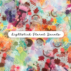 May include: A collection of colorful floral decals with a variety of flower designs, compasses, and geometric shapes. The decals are in shades of pink, red, orange, blue, and green. Text on the image reads "Lightstick Floral Decals."