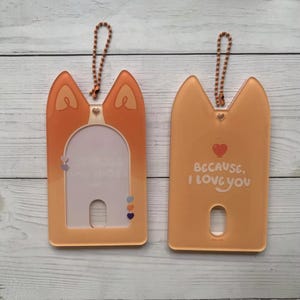 May include: Two orange plastic card holders with a keychain loop. One holder has a clear window and the other has the text "Because, I love you" with a heart.