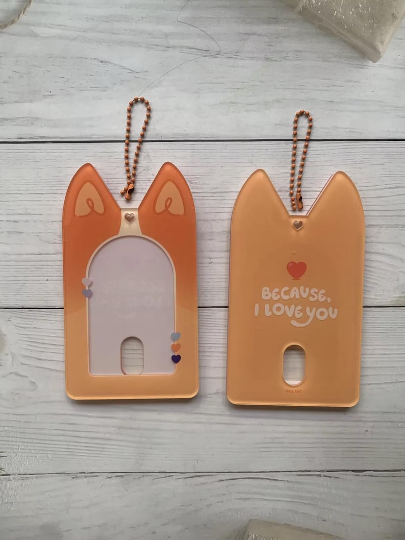 May include: Two orange plastic card holders with a keychain loop. One holder has a clear window and the other has the text "Because, I love you" with a heart.