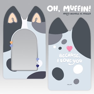 May include: A blue and gray patterned phone stand with a cat-shaped design. The stand has a cutout for a phone and says "OH, MUFFIN! MUFFY-INSPIRED PC HOLDER" at the top. The stand also has the text "BECAUSE, I LOVE YOU" and "ORIL KAT" at the bottom.