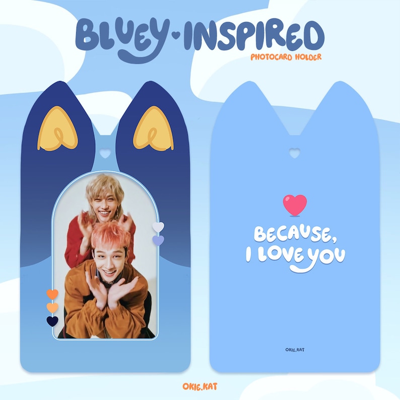 May include: Blue and yellow photo card holder with a cat-shaped design. The holder has a cutout for a photo and the text "Because, I love you" on the front. The back of the holder has the text "okie.kat" in white.