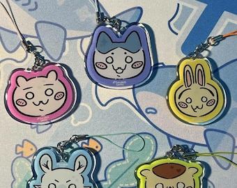 May include: Five acrylic charms featuring cartoon animal faces with pink cheeks. The charms are circular or shaped like animal heads, colored in pink, purple, yellow, light blue, and lime green, each attached to a thin cord for hanging.