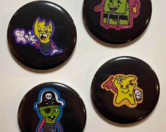 May include: Four black round buttons with cartoon character designs. One button features a yellow lightbulb character with a broken head and a purple cloud. Another shows a green box character with a pink outline. The third button has a green lightbulb pirate. The last button has a yellow star character.