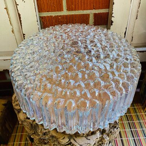 May include: A clear glass ceiling light fitting with a textured, bubble-like design. The light fitting is round and has a diameter of approximately 30 cm.