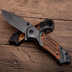 May include: A gray pocket knife with a wooden handle. The handle is engraved with the date "3.10.2021" and the text "Happy 1st Anniversary Always & Forever".
