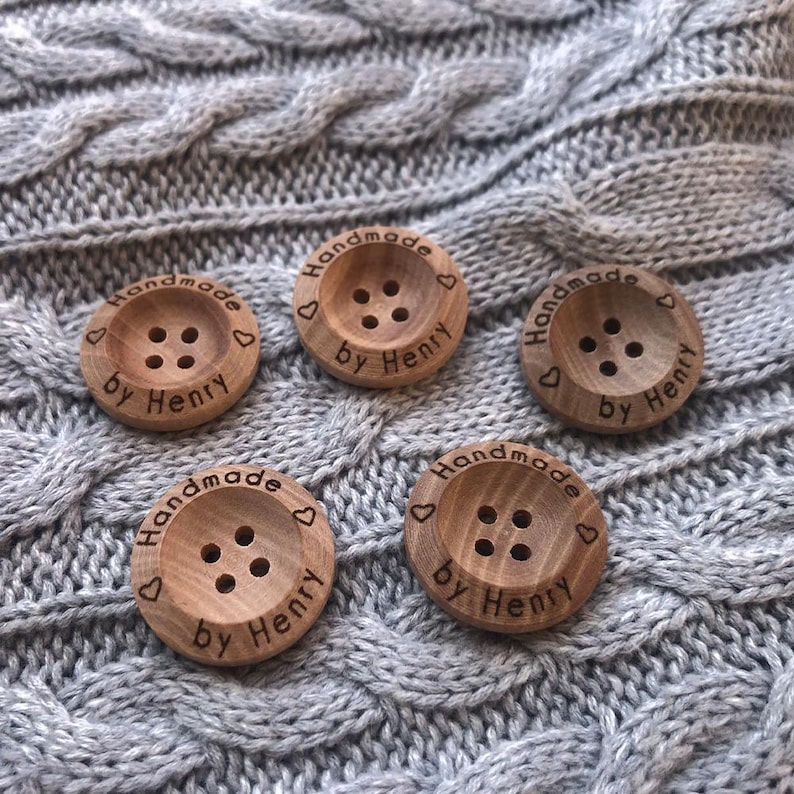 May include: Five wooden buttons with the text "Handmade by Henry" and a heart symbol engraved on each button.