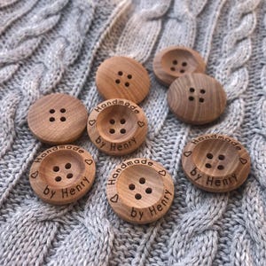 May include: A set of eight wooden buttons with four-hole design. The buttons are engraved with the text "Handmade by Henry" and a heart symbol.