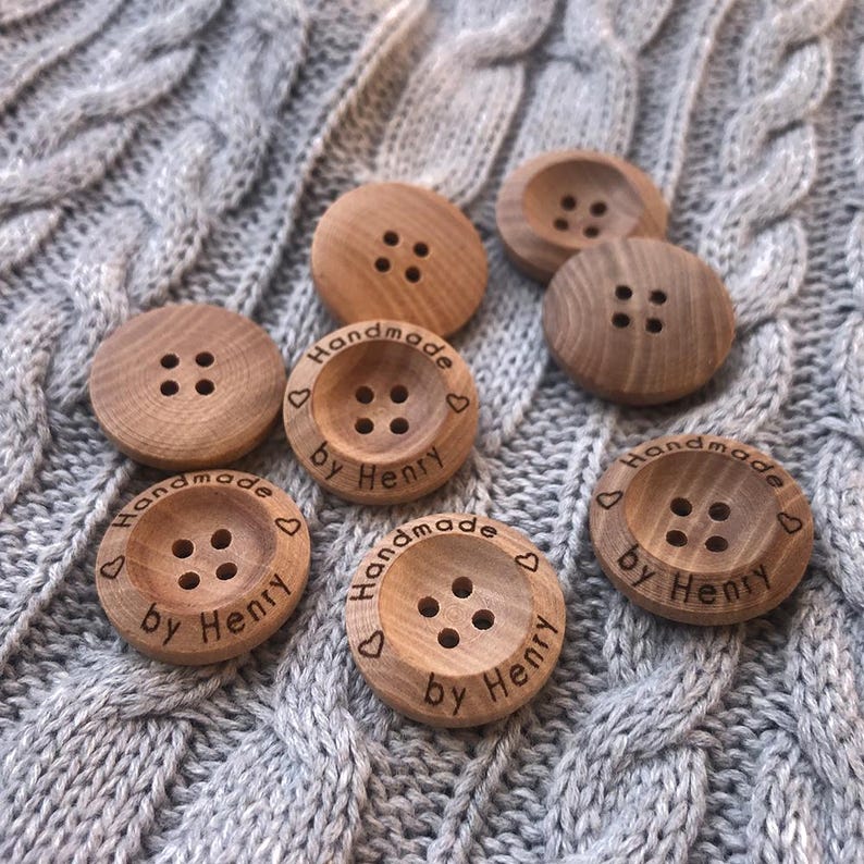 May include: A set of eight wooden buttons with four-hole design. The buttons are engraved with the text "Handmade by Henry" and a heart symbol.
