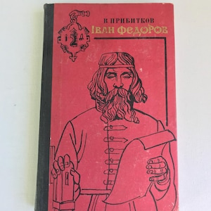 Puede incluir: Una cubierta de libro roja con un borde negro. La cubierta presenta una ilustración en blanco y negro de un hombre con barba y una cinta para la cabeza. El título del libro es "Иван Федоров" en letras doradas. El texto "В. Прыбытков" está en letras doradas más pequeñas sobre el título.