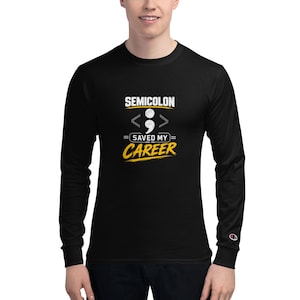 May include: A black long-sleeve crew neck shirt featuring a graphic print with the text SEMICOLON SAVED MY CAREER. The design includes a white semicolon symbol centered between two gray angle brackets, with the word CAREER in yellow text below.