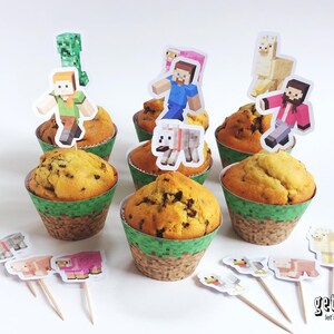May include: Cupcakes with chocolate chips in green and brown paper cups, topped with Minecraft character decorations. Additional character toppers are arranged in front of the cupcakes. The cupcakes are on a white surface.