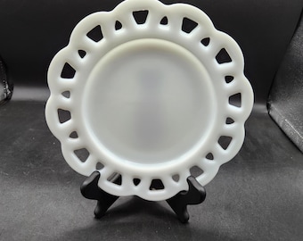 May include: White milk glass plate with a scalloped edge and a cut-out design. The plate is on a black stand.