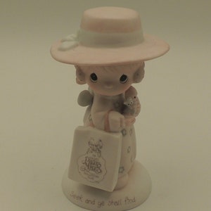 以下が含まれることがあります： ピンクの帽子とドレスを着た女の子の磁器製フィギュアで、