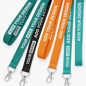 May include: A collection of colorful lanyards with metal clasps. The lanyards are teal, black, and orange, with white text that reads "YOUR LOGO YOUR DESIGN" and "ADD YOUR DESIGN".