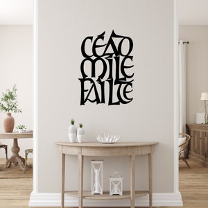 May include: A black and white wall decal with the Irish phrase "Cead Mile Failte" which translates to "A Hundred Thousand Welcomes".