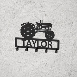 May include: Black metal tractor key holder with the name "TAYLOR" on the bottom. The key holder has five hooks.