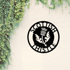 May include: Black metal circle sign with the words "Scottish Thistle" around the edge. The centre of the sign features a white silhouette of a thistle flower.