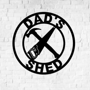 May include: Black metal sign with the words "Dad's Shed" in a circle. A hammer and saw are crossed in the centre of the circle.
