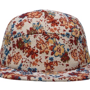 May include: A beige, red and blue patterned baseball cap with a curved brim. The cap is made of a woven fabric with a floral design.