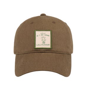 May include: A brown baseball cap with a curved brim. The cap features a square patch with the text "Y'all mind IF I DO SOME LOLLYGAGGIN'" and a cartoon image of a pig. The cap has a button on top.