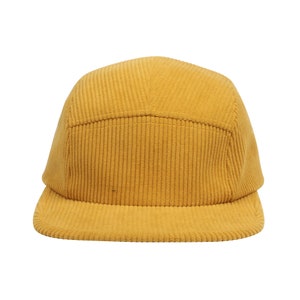 May include: A yellow corduroy baseball cap with a flat brim.