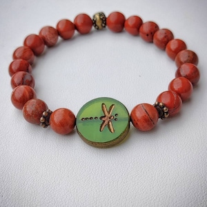 Elastisches Armband aus roten Jaspisperlen mit einem zentralen böhmischen Glas, das mit einer Libelle verziert ist