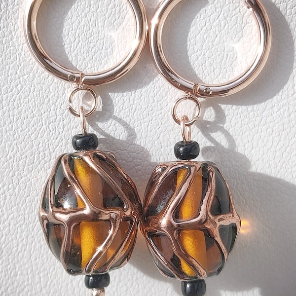 Orecchini pendenti con monachella in acciaio inox e Czech Lampwork color ambra con rilievi in metallo rose gold