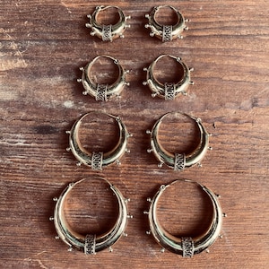 Op de afbeelding: Set van zes gouden creolen met decoratieve details. De creolen zijn in verschillende maten, de grootste heeft een diameter van ongeveer 5 cm.