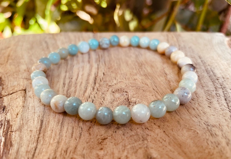 May include: A light blue and white beaded bracelet made of natural stones. The bracelet is made of round beads and is approximately 7 inches in length.
