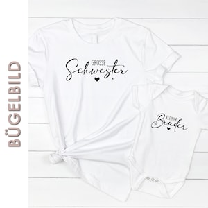 Könnte beinhalten: Zwei weiße T-Shirts mit schwarzem Text. Das größere Shirt sagt "Grosse Schwester" mit einem kleinen Herz. Das kleinere Shirt sagt "Kleiner Bruder" mit einem kleinen Herz.
