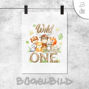 Pode incluir: Uma impressão branca com animais da floresta, a palavra «Wild» e o número «ONE». A ilustração inclui um urso, uma coruja, uma raposa, um coelho e um alce. A impressão é mantida por dois clipes pretos sobre um fundo cinza.