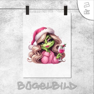 Könnte beinhalten: Digitale Illustration eines grünen Charakters mit langen blonden Haaren, der einen rosa Weihnachtsmannhut und einen Pullover trägt und ein Glas rosa Wein hält. Das Bild ist auf weißem Papier gedruckt und mit "BÜGELBILD" beschriftet.