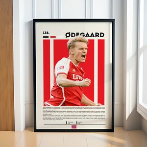 May include: A red and white poster with a photo of a soccer player celebrating a goal. The poster has the text "138. ØDEGAARD" at the top and a small Norwegian flag at the bottom. The player is wearing a red and white soccer jersey with the number "8" on the back. The poster is a celebration of the soccer player's career.