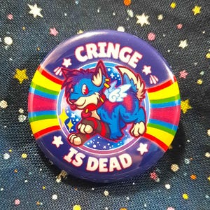 May include: A blue and purple button with a rainbow border. It features a cartoon wolf with wings and the text "Cringe is Dead".