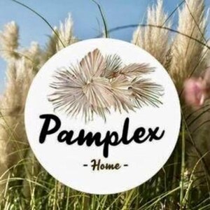 May include: A white circular sign with the word "Pamplex" in black script, and "- Home -" below it. The sign features a beige floral design. The background includes tall, dried grasses.