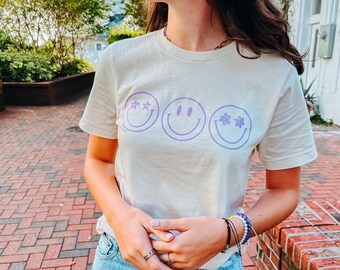 Camiseta Smiley Face: Estampado morado, algodón suave color crema